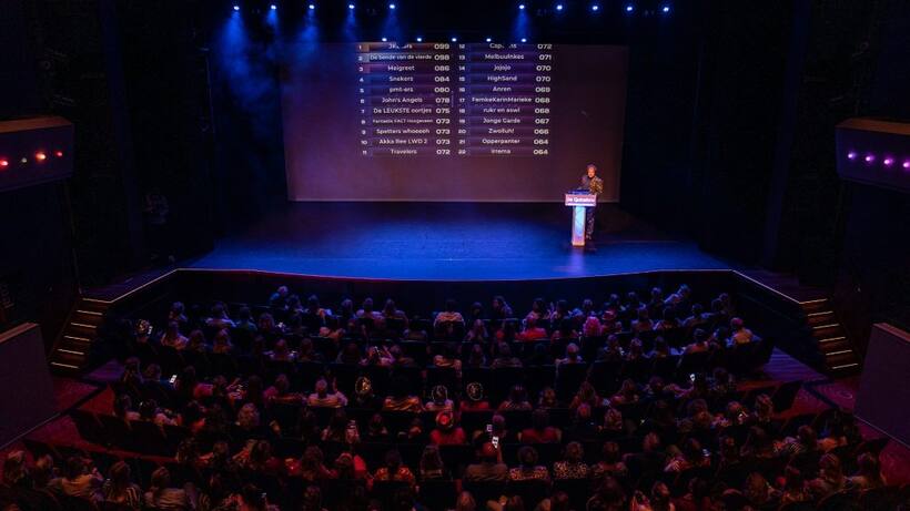 Bouke Koning met microfoon op het podium tijdens een quizshow